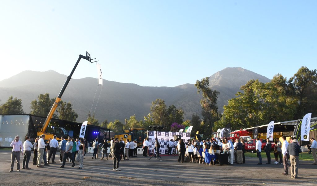 Clientes y colaboradores participan del evento 'After en Salfa' en Santiago, un encuentro al aire libre rodeado de montañas, con maquinaria en exhibición y espacios de conversación, enfocado en fortalecer la cercanía y confianza con los clientes.