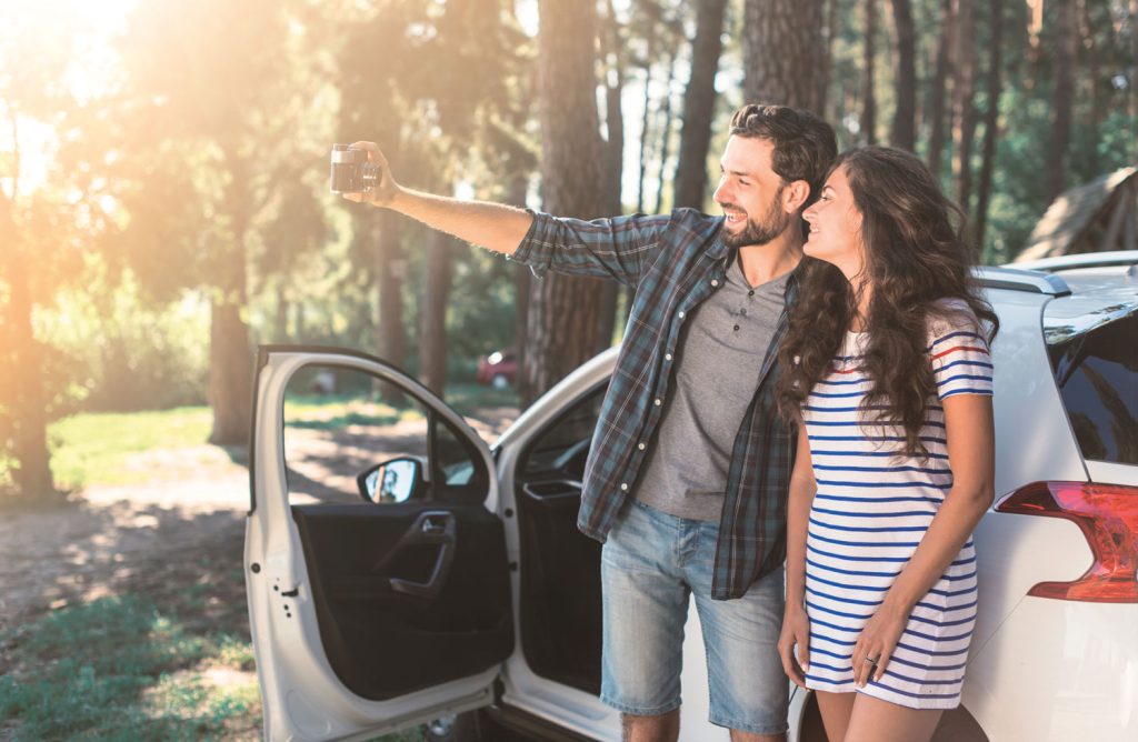 Pareja disfrutando un viaje en auto durante sus vacaciones, preparada para salir a ruta con su vehículo.